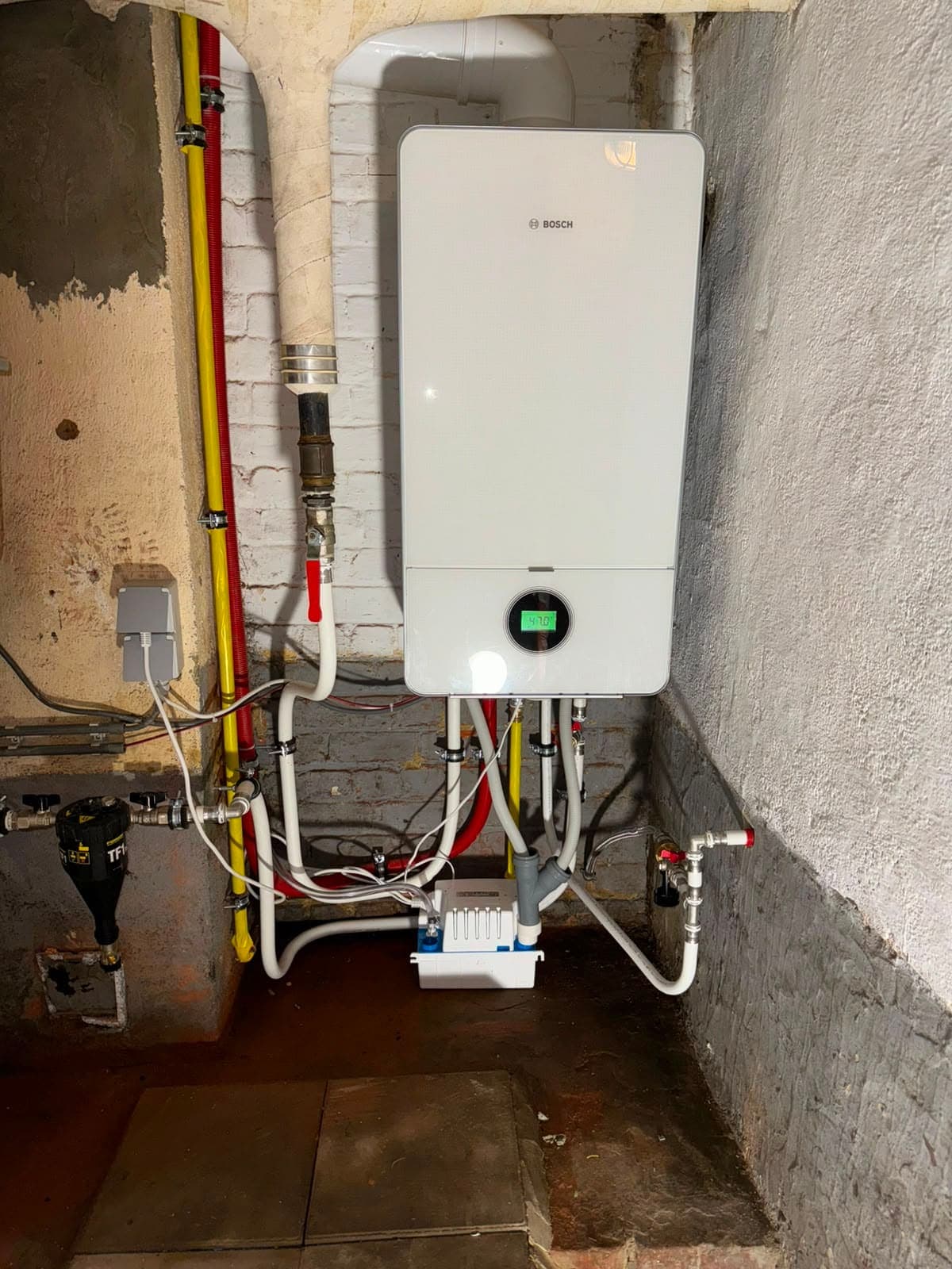 Chaudière murale gaz à condensation Bosch installée en cave, tuyauteries neuves et siphon de condensats